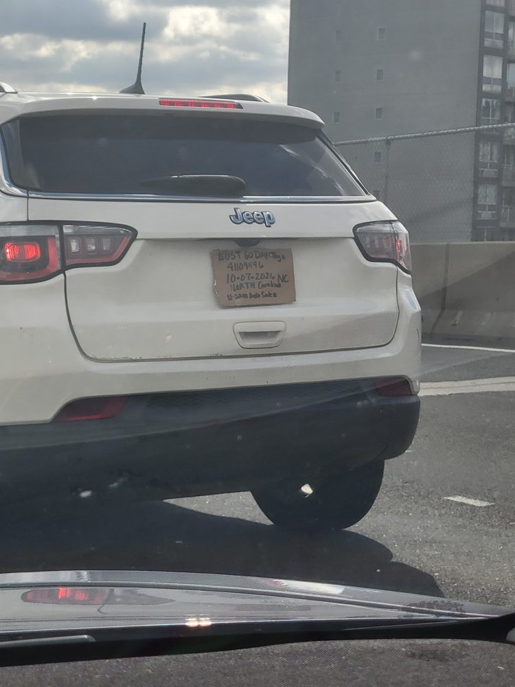 A Jeep with a handwritten cardboard temporary license plate on the Grand Central Parkway