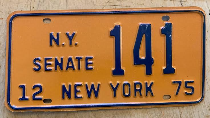 New York 1970s orange license plate with dark blue characters